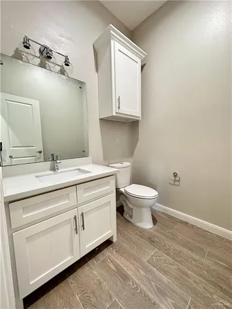 a bathroom with a granite countertop toilet sink and mirror
