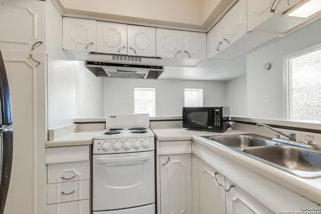 a kitchen with appliances cabinets and a sink