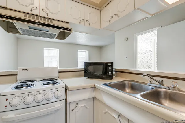 a kitchen with stainless steel appliances granite countertop a sink and a stove