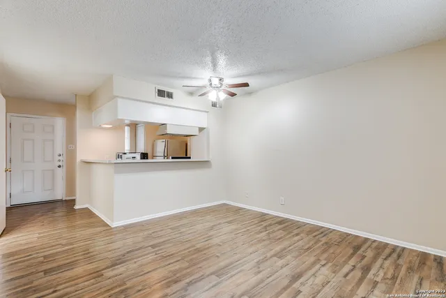 a view of a kitchen with wooden cabinet and a ceiling fan