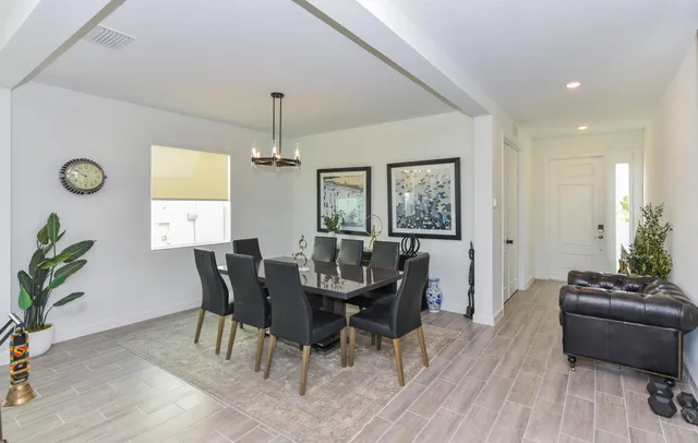 a kitchen with stainless steel appliances kitchen island granite countertop a table chairs and a refrigerator