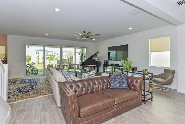 a kitchen with stainless steel appliances kitchen island a refrigerator a stove a sink and white cabinets with wooden floor