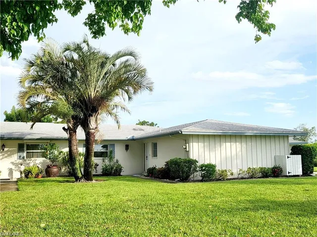 a front view of a house with a garden and yard