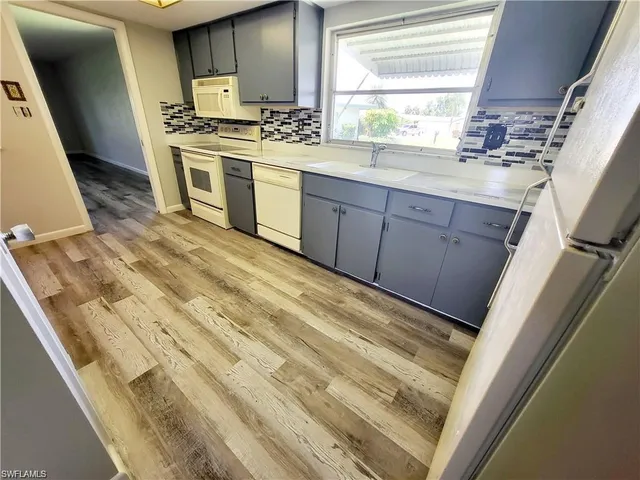 a kitchen with granite countertop cabinets a sink a window and stainless steel appliances