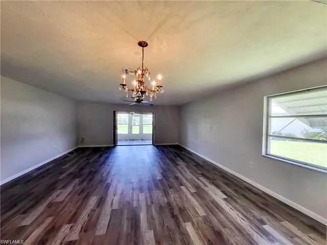 a view of a room with wooden floor chandelier and window