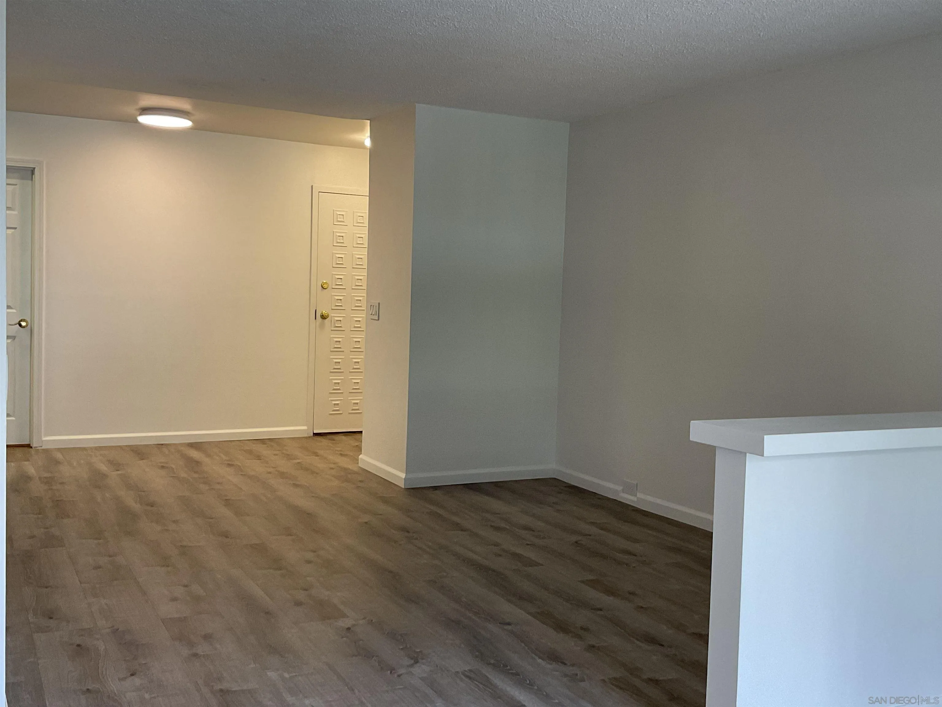 2600 Torrey Pines Road, Unit A25 La Jolla, CA 92037 - Photo 14 of 47 a view of an empty room with wooden floor and a window