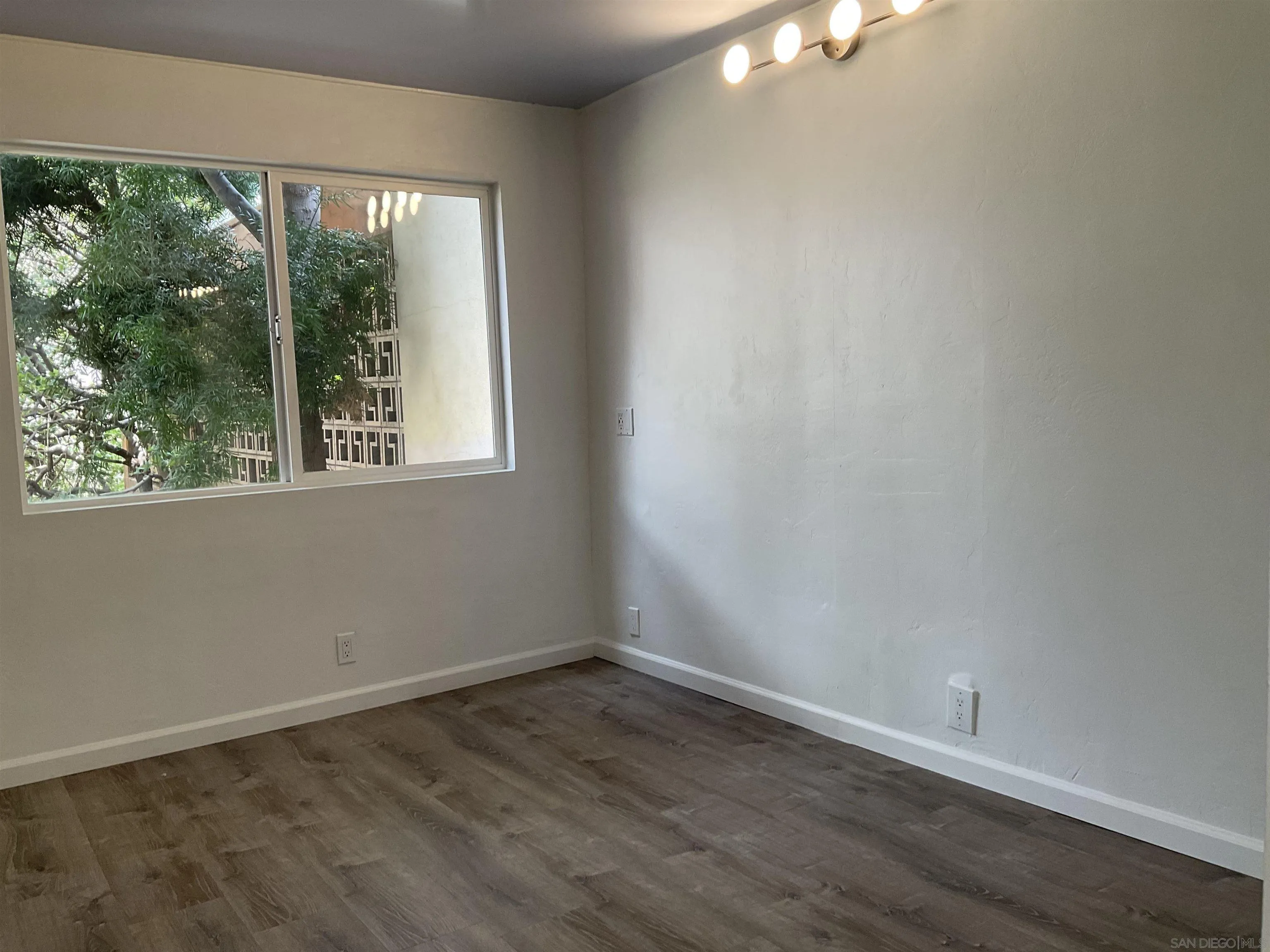 2600 Torrey Pines Road, Unit A25 La Jolla, CA 92037 - Photo 40 of 47 an empty room with wooden floor and windows