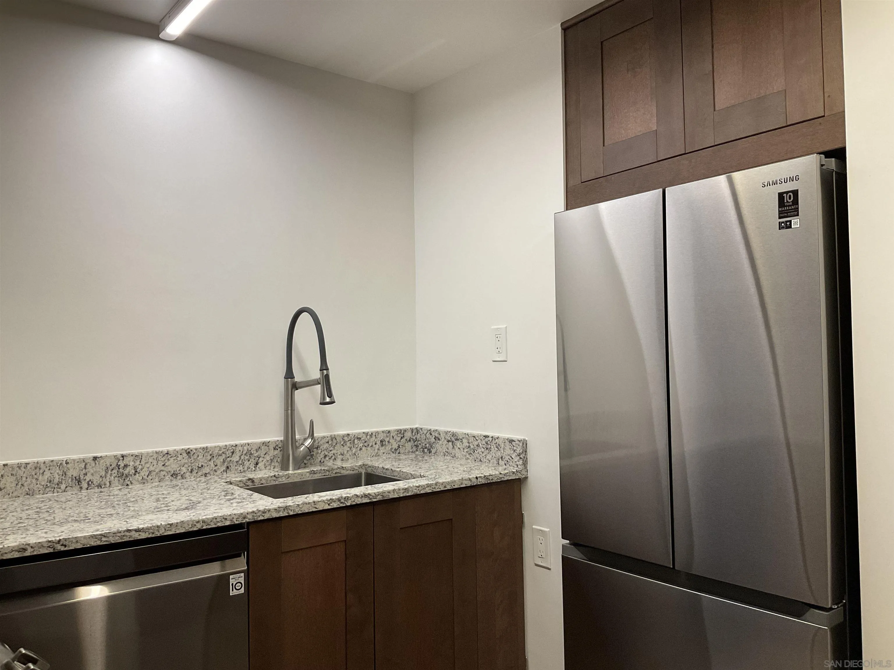 2600 Torrey Pines Road, Unit A25 La Jolla, CA 92037 - Photo 7 of 47 a kitchen with granite countertop a refrigerator and a sink