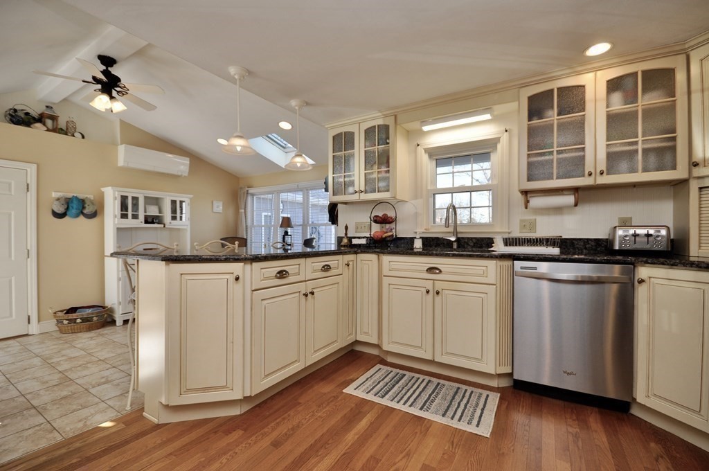 316 Shore Road Bourne, MA 02532 - Photo 17 of 39 a kitchen with stainless steel appliances granite countertop a stove a sink dishwasher and white cabinets with wooden floor
