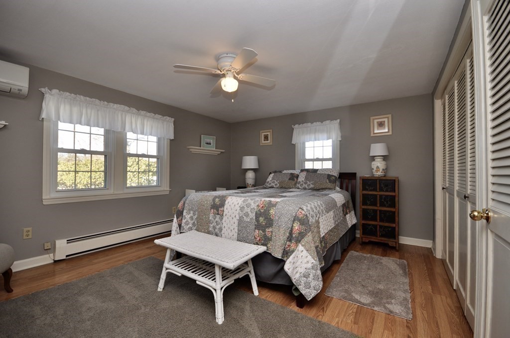 316 Shore Road Bourne, MA 02532 - Photo 27 of 39 a spacious bedroom with a bed and a chandelier