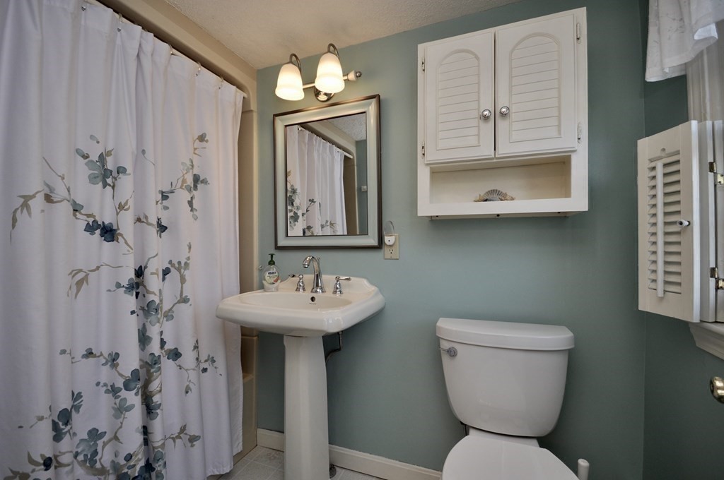 316 Shore Road Bourne, MA 02532 - Photo 33 of 39 a bathroom with a toilet sink and mirror