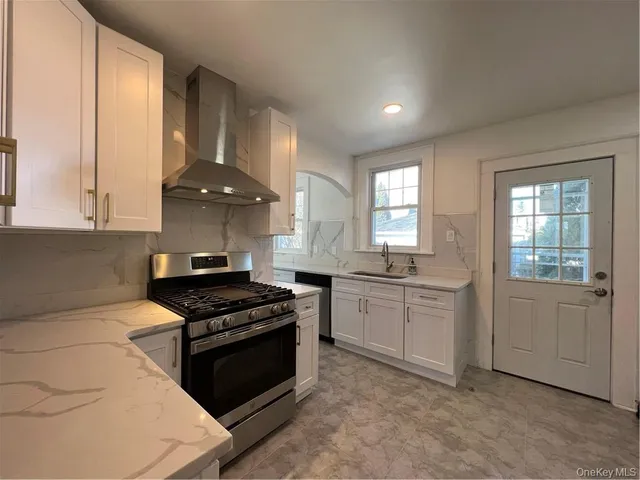 a kitchen with granite countertop white cabinets and appliances