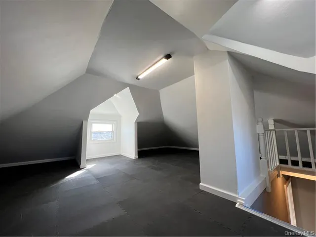an empty room with staircase and white walls