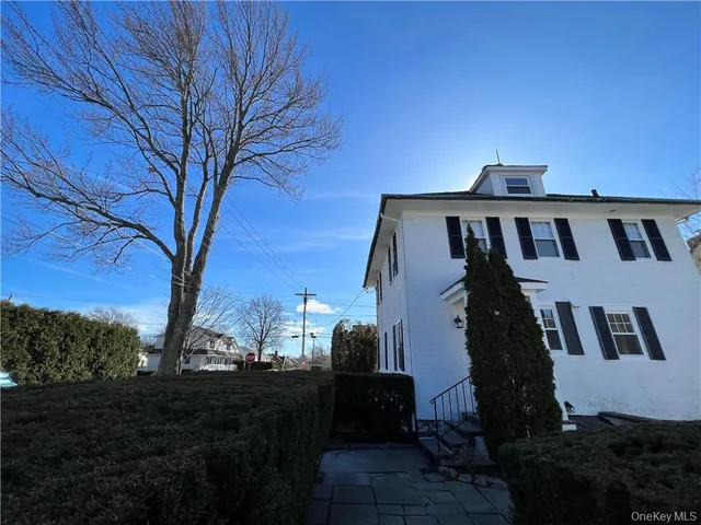 a view of a house with backyard and trees