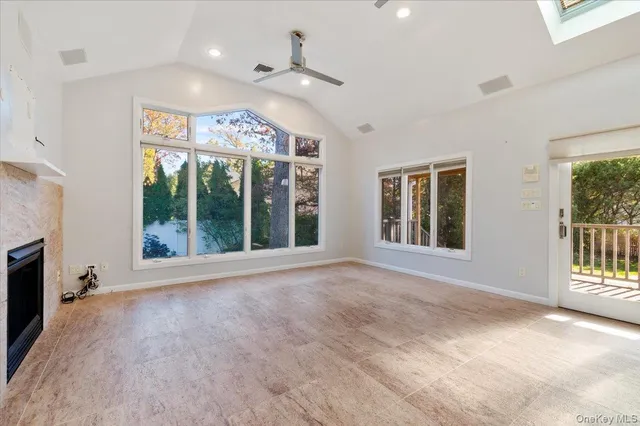 a view of an empty room with a window and a kitchen