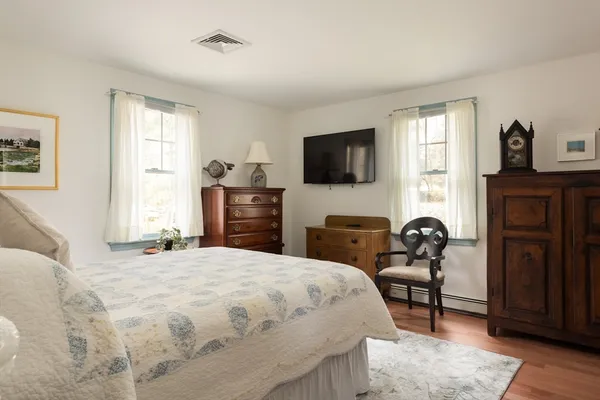 a bedroom with a bed and furniture with wooden floor