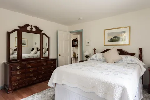 a bedroom with a bed and a mirror on dresser