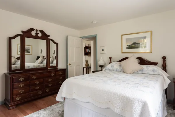 a bedroom with a bed and a mirror on dresser