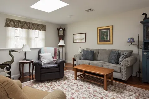 a living room with furniture lamp and a large window