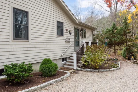 a view of a house with a yard and potted plants
