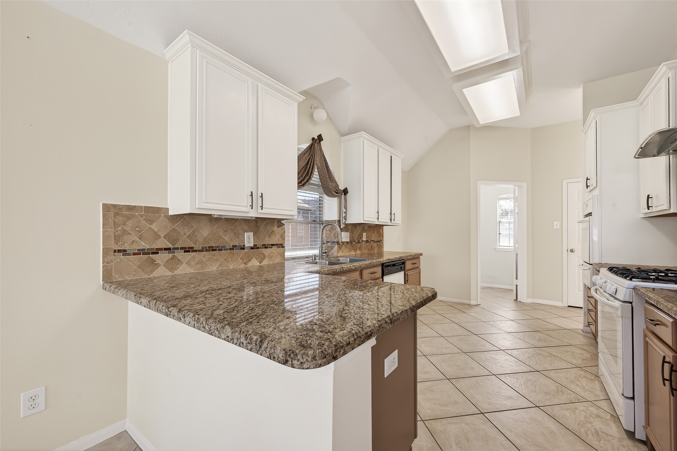 20839 Rivershire Lane Houston, TX 77073 - Photo 20 of 50 a kitchen with kitchen island granite countertop a sink a stove and cabinets