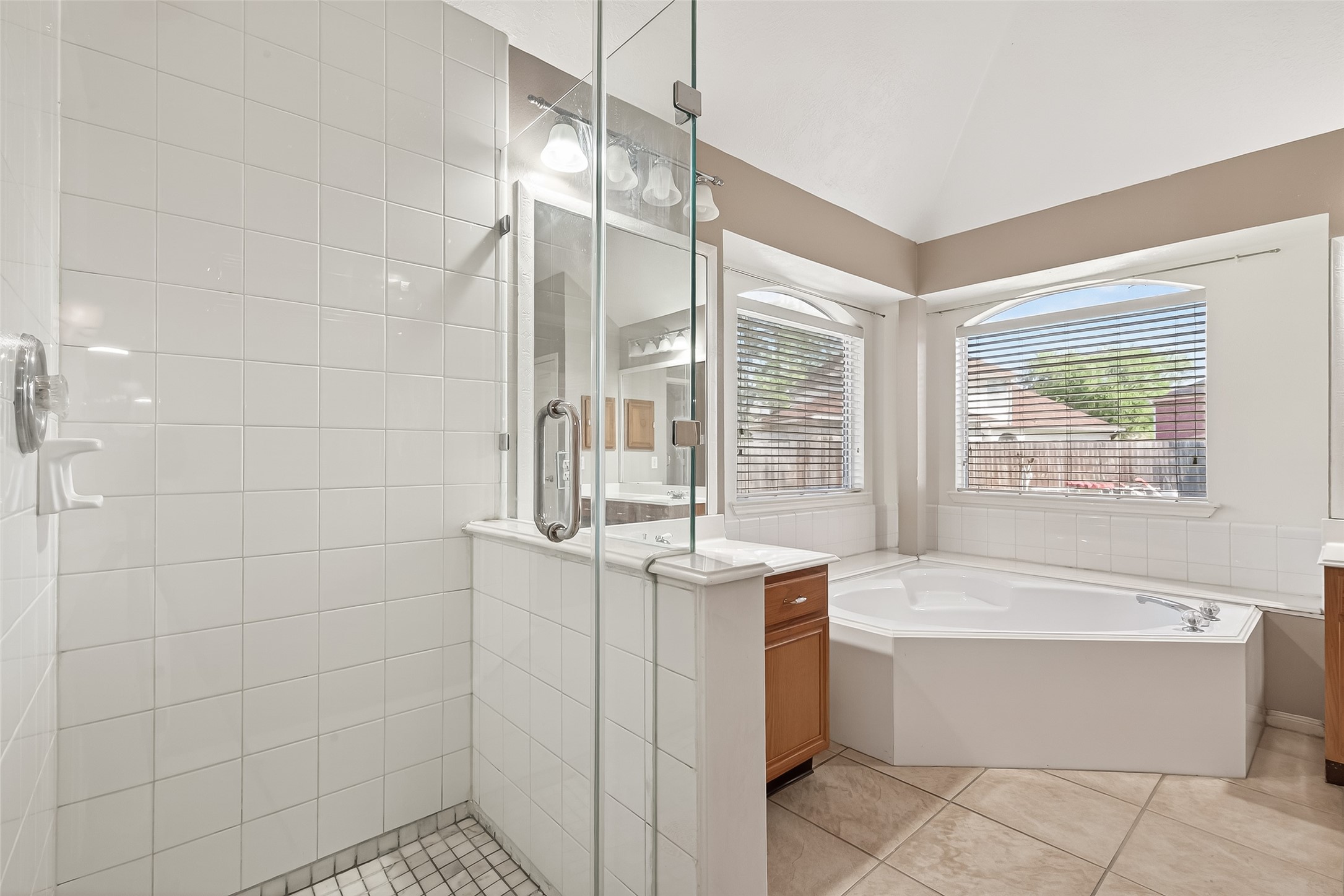 20839 Rivershire Lane Houston, TX 77073 - Photo 43 of 50 a bathroom with a bathtub a sink a mirror and a shower