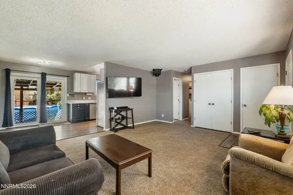a living room with stainless steel appliances furniture a refrigerator a kitchen island a stove a refrigerator cabinets and furniture
