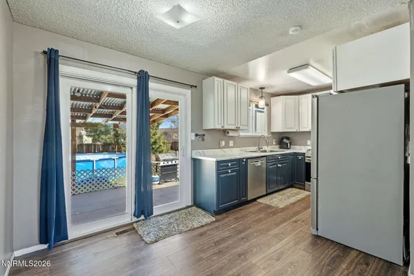 a kitchen with stainless steel appliances granite countertop a refrigerator a stove a sink and a microwave