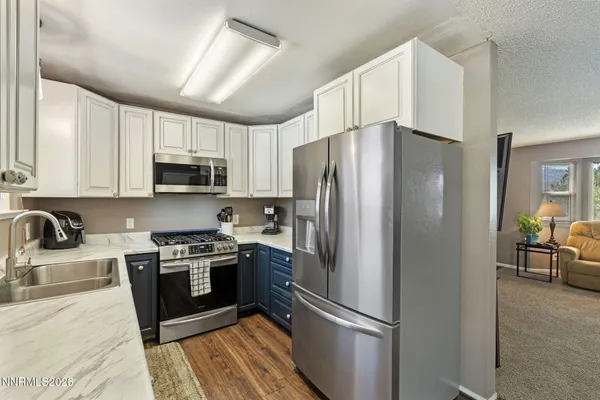 a kitchen with stainless steel appliances granite countertop a sink stove and cabinets