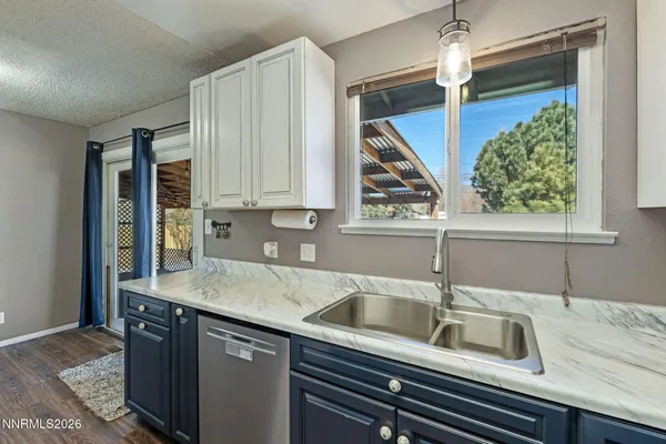 a kitchen with granite countertop a refrigerator and a sink