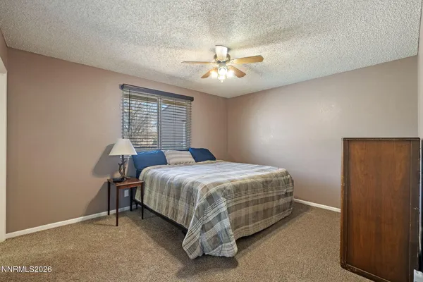 a bedroom with a large bed and a ceiling fan