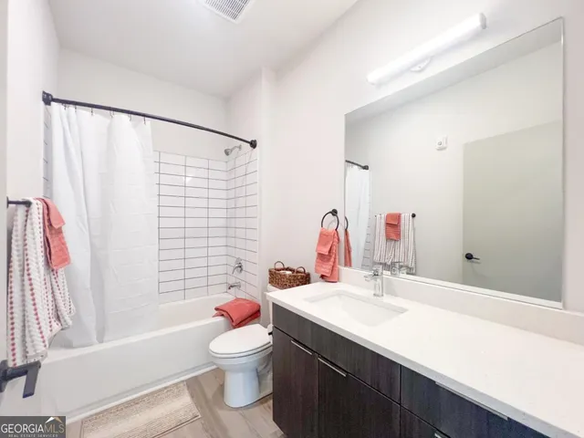 a bathroom with a sink toilet vanity and tub
