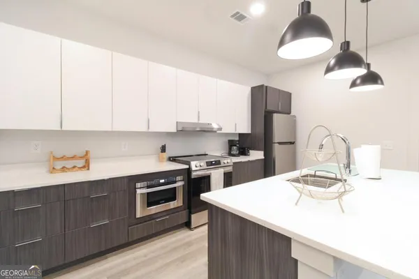 a kitchen with a sink a stove and oven