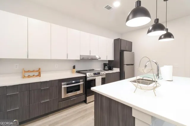 a kitchen with a sink a stove and oven