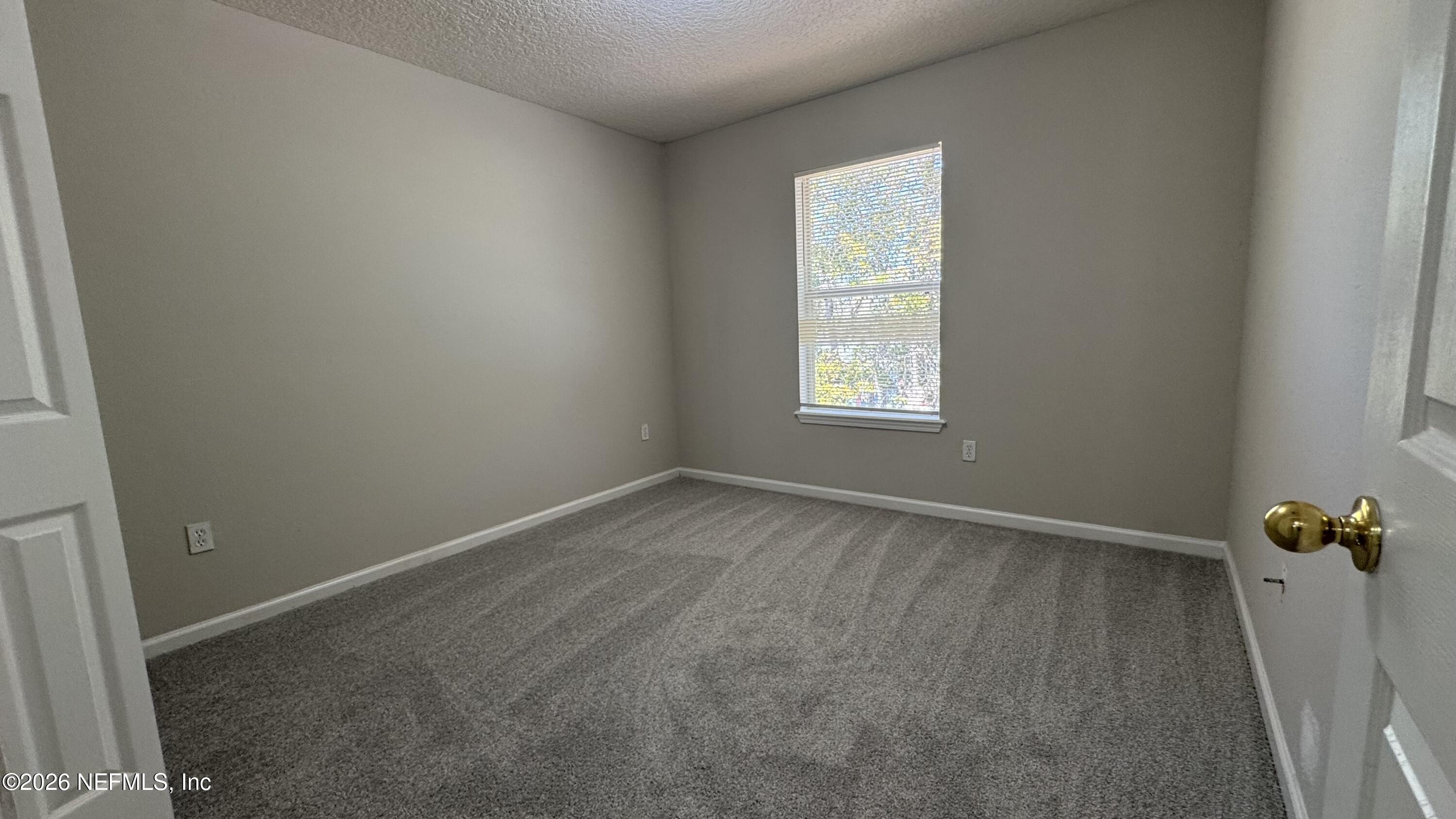 5260 Collins Road, Unit 1504 Jacksonville, FL 32244 - Photo 11 of 12 an empty room with windows