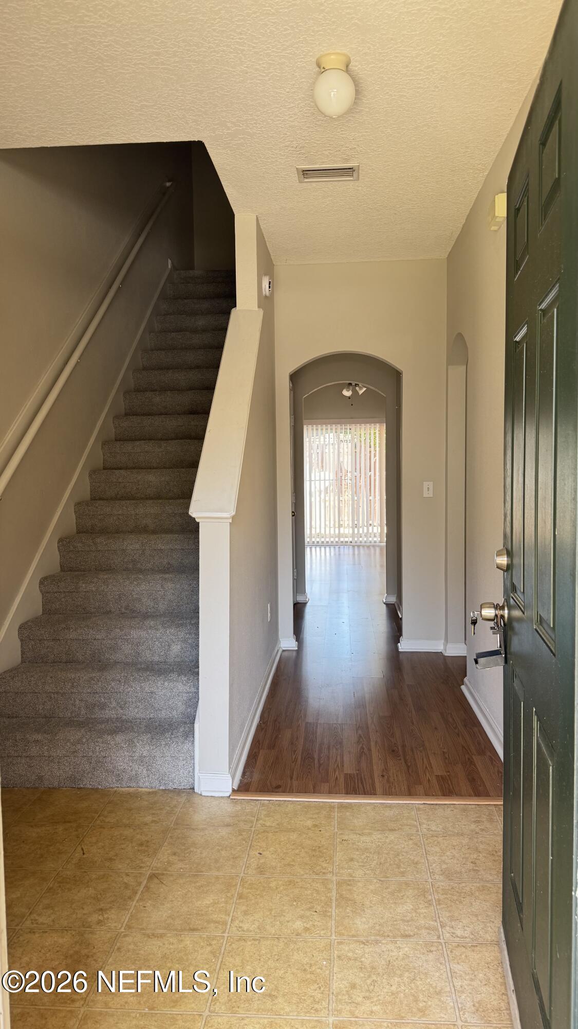 5260 Collins Road, Unit 1504 Jacksonville, FL 32244 - Photo 2 of 12 a view of a hallway with wooden floor and staircase