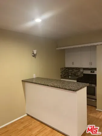 a kitchen with granite countertop a sink and a stove