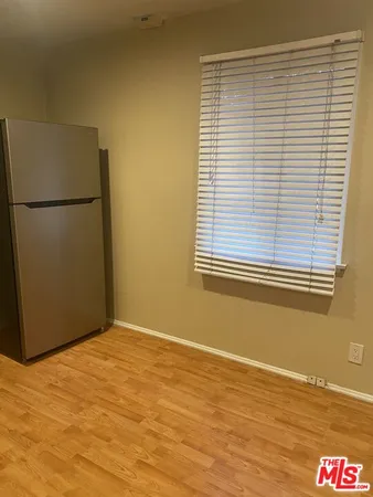 a view of a room with wooden floor and a window