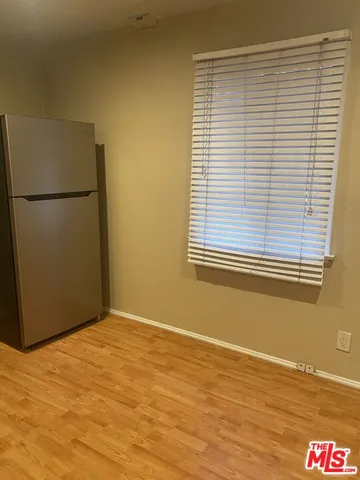 a view of a room with wooden floor and a window