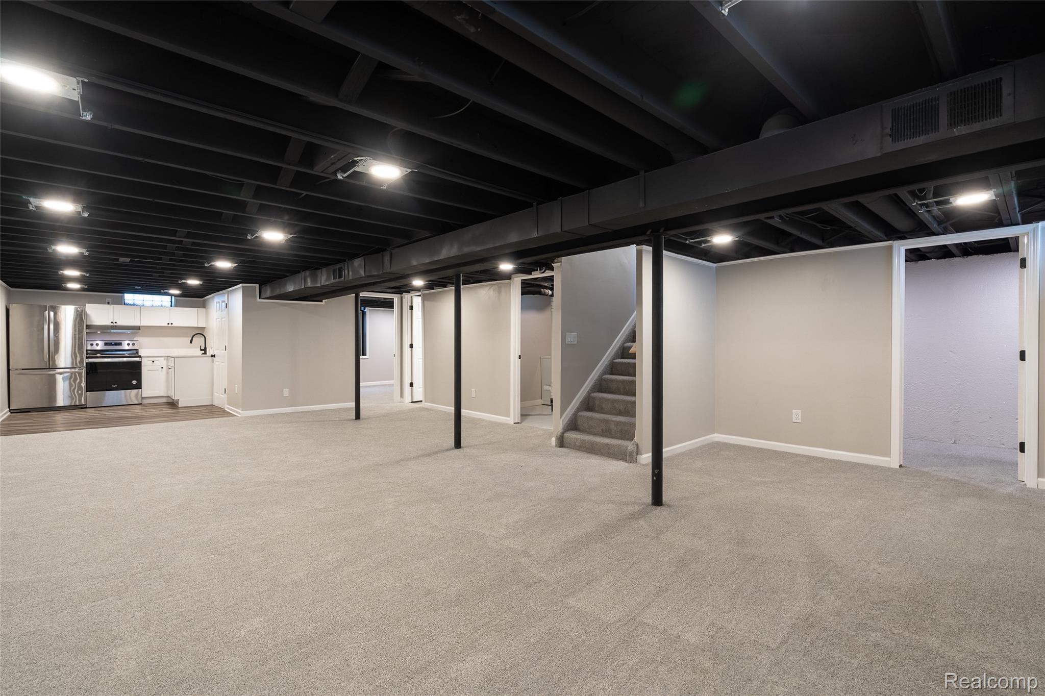 201 Cardwell Street Inkster, MI 48141 - Photo 30 of 41 Spacious finished basement featuring light gray carpeting, neutral-toned walls, and a recessed lighting system in the exposed black ceiling