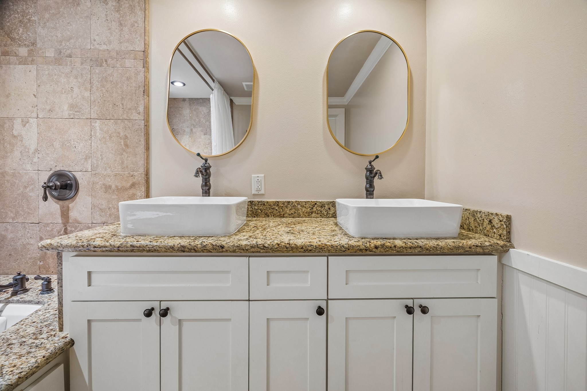4412 Rusk Street Houston, TX 77023 - Photo 18 of 44 Primary bath features granite vanity with dual rectangular vessel sinks, framed mirror & stylish hardware. Beautiful cabinetry offers abundant storage.