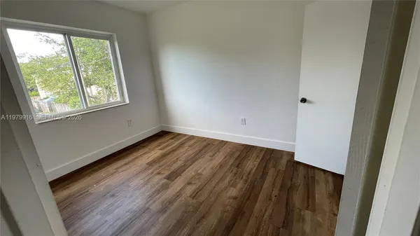 a view of a room with wooden floor and window