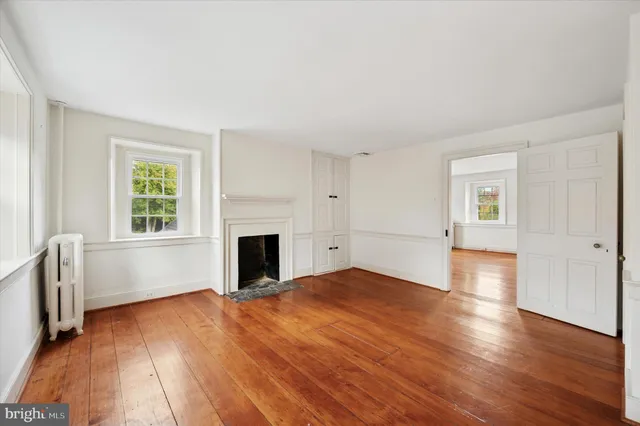 a view of empty room with wooden floor and fireplace