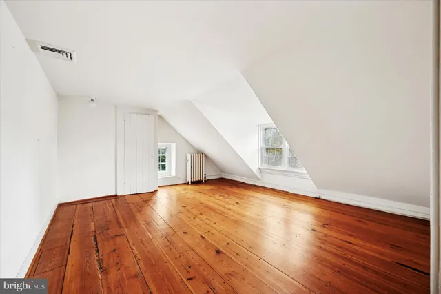 a view of empty room with wooden floor
