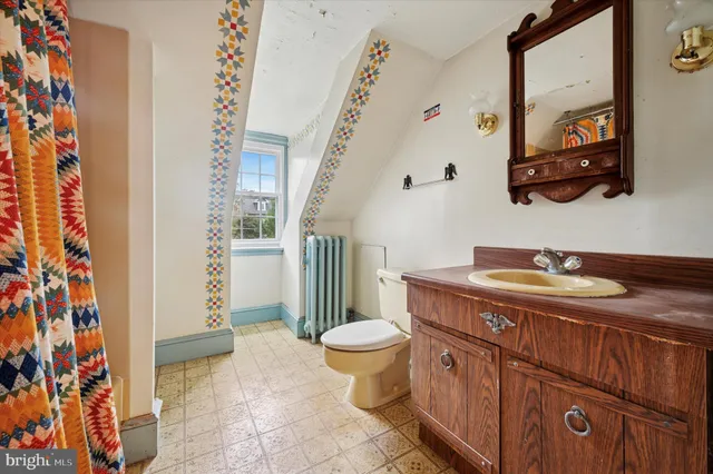 a bathroom with a granite countertop sink a toilet and a shower curtain