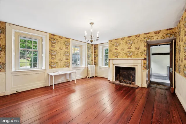 wooden floor fireplace and windows in an empty room