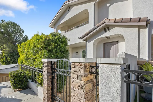 a view of a house with wooden fence