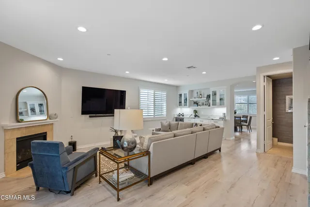 a living room with furniture flat screen tv and wooden floor