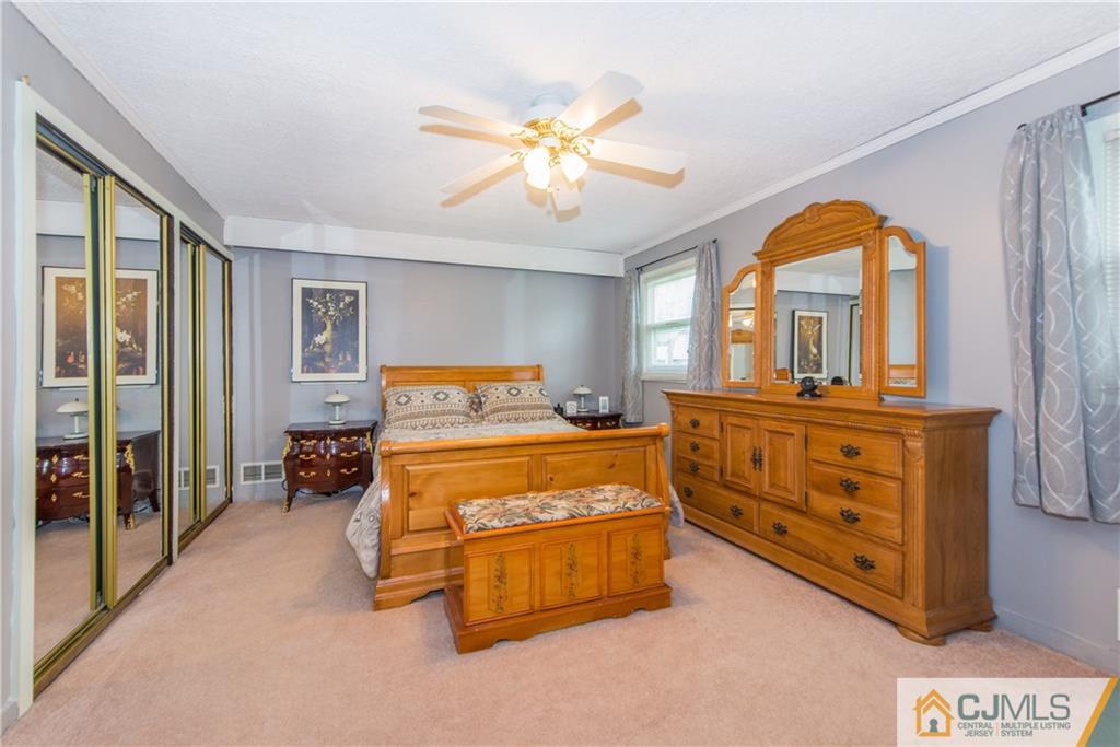 127 Idlewild Road Edison, NJ 08817 - Photo 16 of 21 a bedroom with a bed and a chandelier