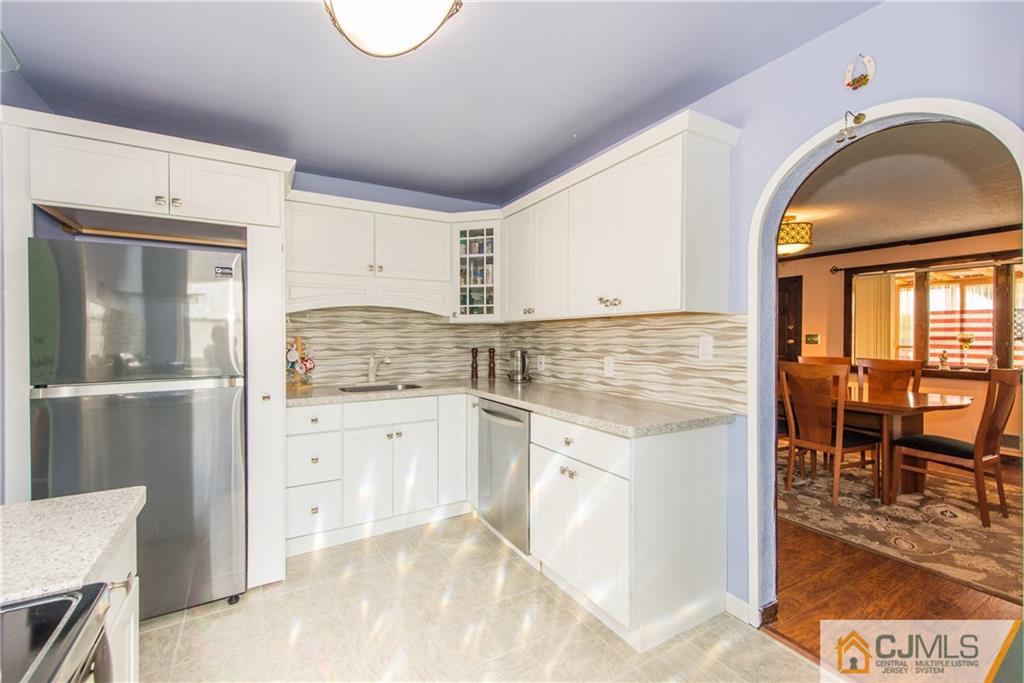 127 Idlewild Road Edison, NJ 08817 - Photo 7 of 21 a kitchen with granite countertop a stove a sink and a refrigerator